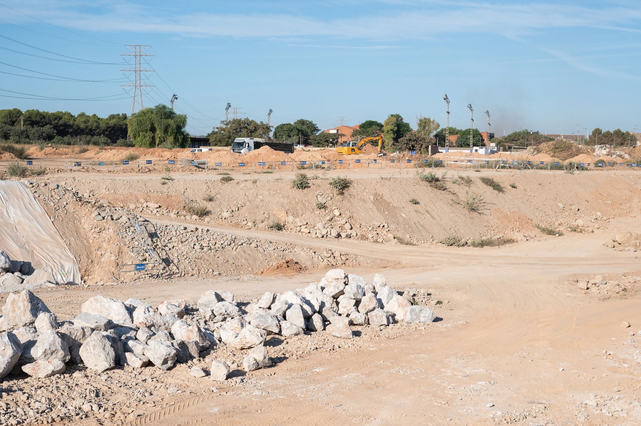 Earthworks underway at a large construction site with an excavator and truck